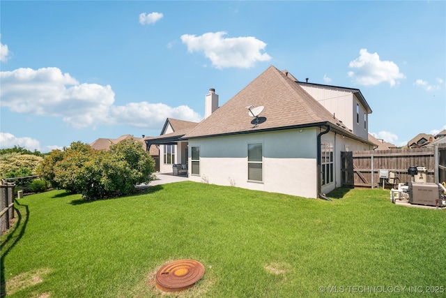 rear view of property featuring roof with shingles, stucco siding, a fenced backyard, a chimney, and a lawn