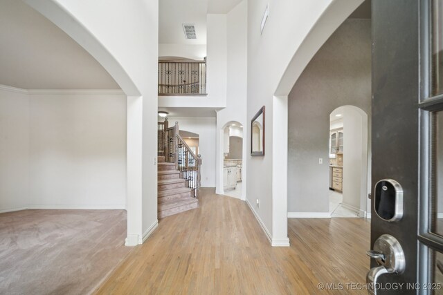 8655 E 103rd St, Tulsa, OK 74133 - foyer entrance with a high ceiling, arched walkways, wood finished floors, and baseboards