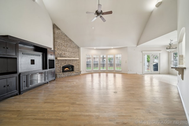 8655 E 103rd St, Tulsa, OK 74133 - unfurnished living room featuring high vaulted ceiling, light wood finished floors, ceiling fan, a large fireplace, and baseboards