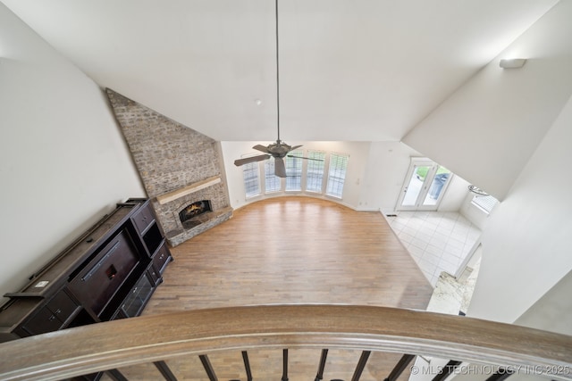 8655 E 103rd St, Tulsa, OK 74133 - unfurnished living room featuring a fireplace, a ceiling fan, wood finished floors, and high vaulted ceiling