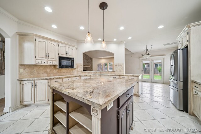 8655 E 103rd St, Tulsa, OK 74133 - kitchen with freestanding refrigerator, black microwave, light tile patterned floors, tasteful backsplash, and a center island