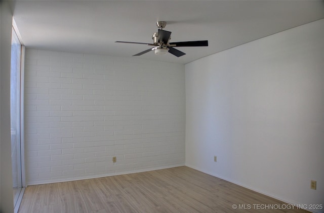 empty room featuring baseboards, a ceiling fan, and light wood-style flooring