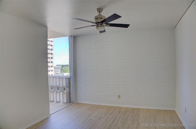 spare room with baseboards, light wood-style flooring, and ceiling fan
