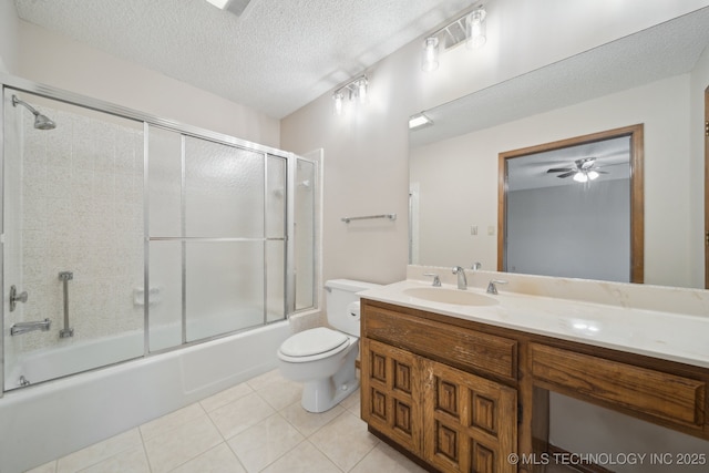 full bath with a textured ceiling, tile patterned flooring, vanity, combined bath / shower with glass door, and toilet