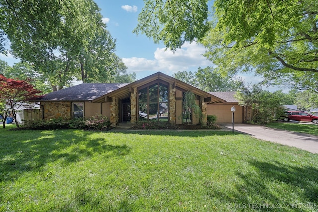 mid-century modern home with a garage, a front lawn, driveway, and stone siding