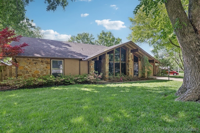 mid-century modern home featuring a shingled roof, a front lawn, and stone siding