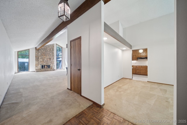 hall featuring baseboards, a textured ceiling, beam ceiling, and light carpet
