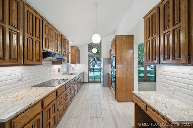 kitchen with under cabinet range hood, backsplash, a sink, and black appliances