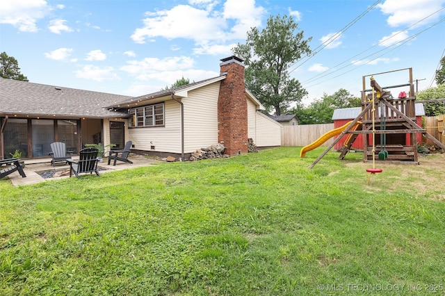 view of yard with a playground, a patio, a fenced backyard, and an outdoor fire pit