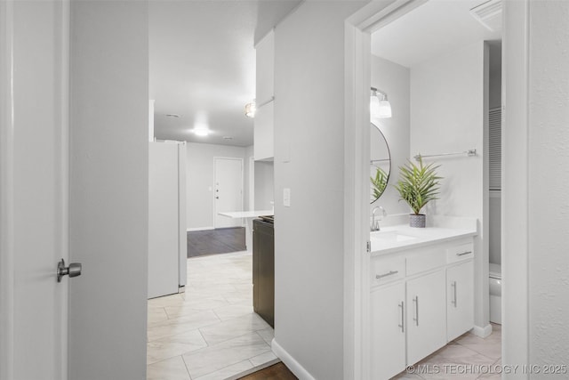 bathroom featuring toilet, marble finish floor, and vanity