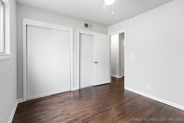 unfurnished bedroom with a ceiling fan, baseboards, visible vents, and wood finished floors