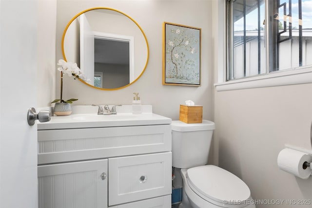half bathroom featuring vanity and toilet