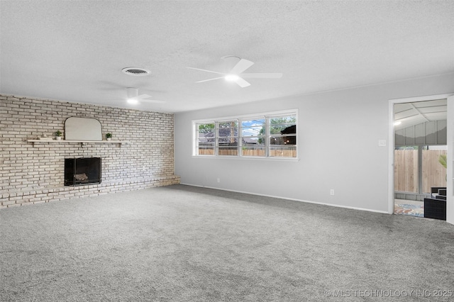 unfurnished living room with visible vents, carpet flooring, a fireplace, a textured ceiling, and a ceiling fan