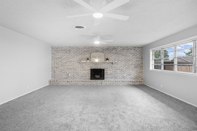 unfurnished living room featuring a textured ceiling, a ceiling fan, brick wall, and visible vents