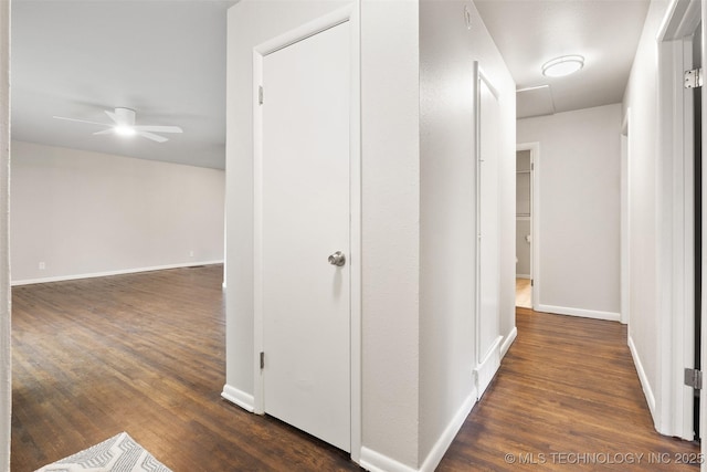 hall featuring baseboards and dark wood-style floors