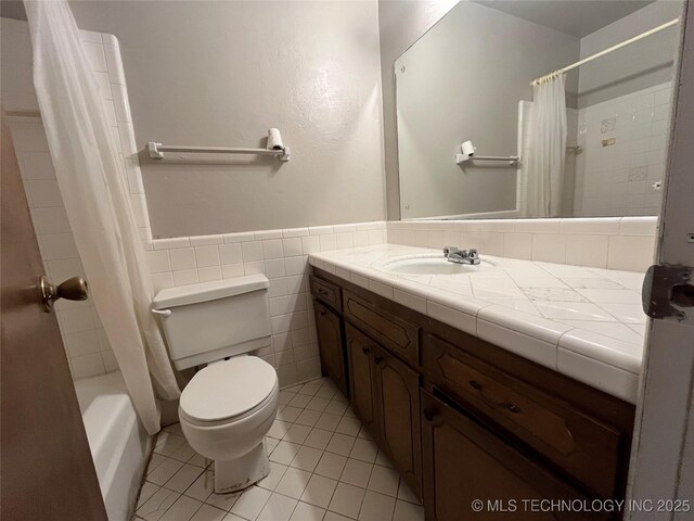 12131 E 31st Pl, Tulsa, OK 74146 - bathroom featuring vanity, tile patterned floors, toilet, wainscoting, and tile walls