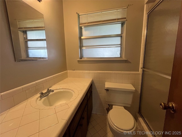 12131 E 31st Pl, Tulsa, OK 74146 - bathroom with tile walls, wainscoting, toilet, tile patterned floors, and vanity