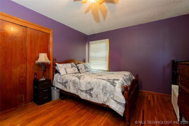 bedroom featuring a textured ceiling, ceiling fan, and wood finished floors