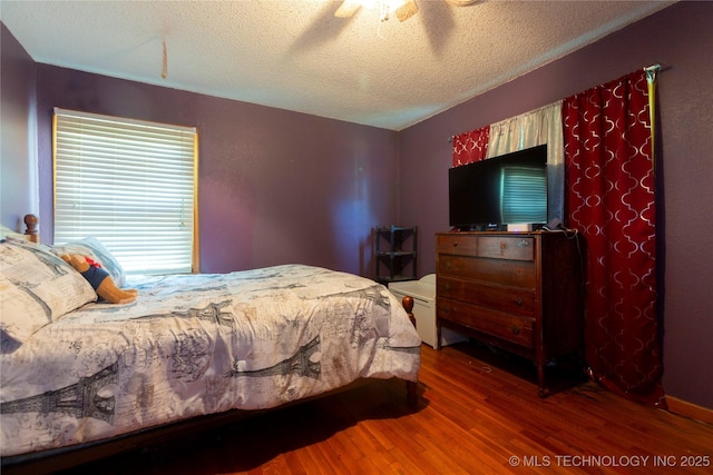bedroom featuring a textured ceiling, ceiling fan, and wood finished floors