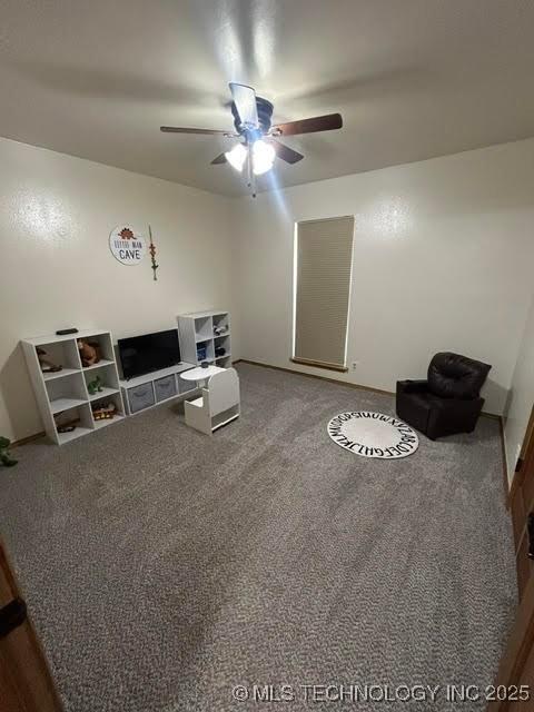 living area featuring carpet flooring and a ceiling fan