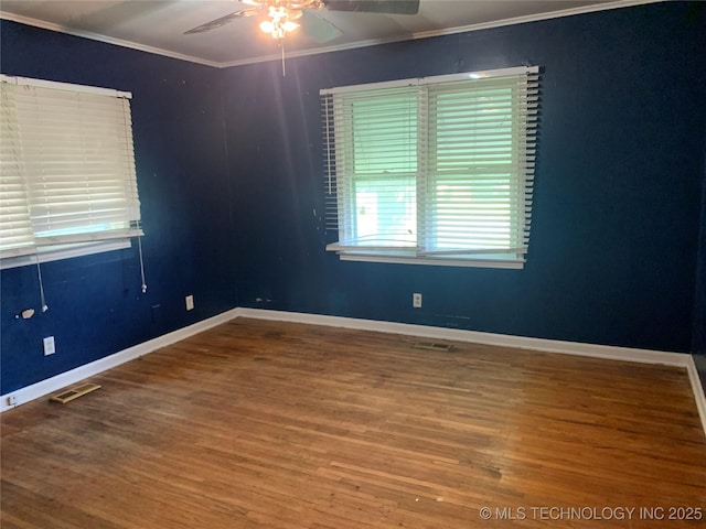 spare room with ceiling fan, ornamental molding, wood finished floors, and visible vents
