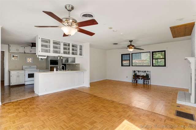 unfurnished living room with visible vents, a ceiling fan, baseboards, and a fireplace with raised hearth