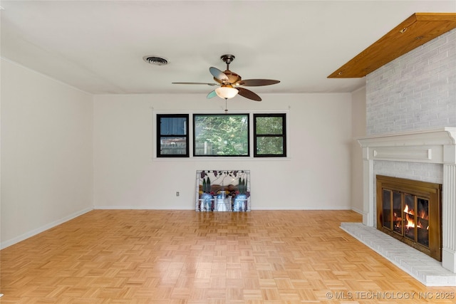 unfurnished living room featuring baseboards, a fireplace, a ceiling fan, and visible vents
