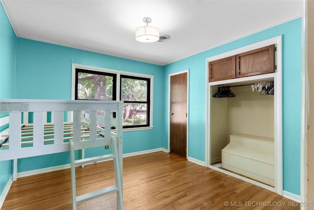 unfurnished bedroom featuring a closet, baseboards, and light wood-type flooring
