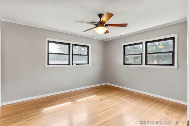 empty room with baseboards, ceiling fan, ornamental molding, and light wood-style flooring