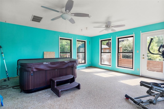 carpeted home office with a ceiling fan and visible vents