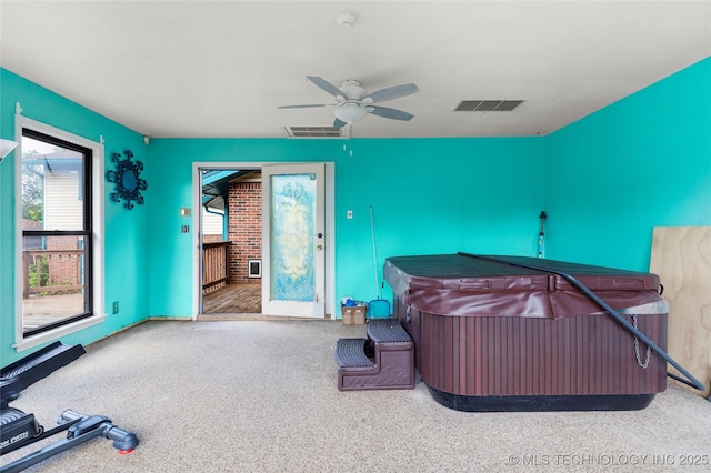 view of patio / terrace featuring visible vents, ceiling fan, and an indoor hot tub