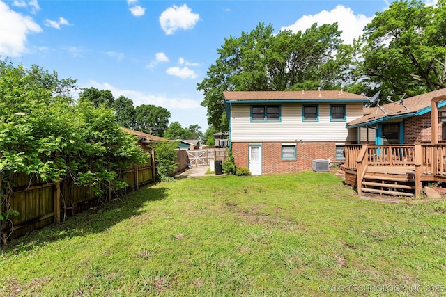 back of house featuring a deck, cooling unit, a fenced backyard, a gate, and a yard