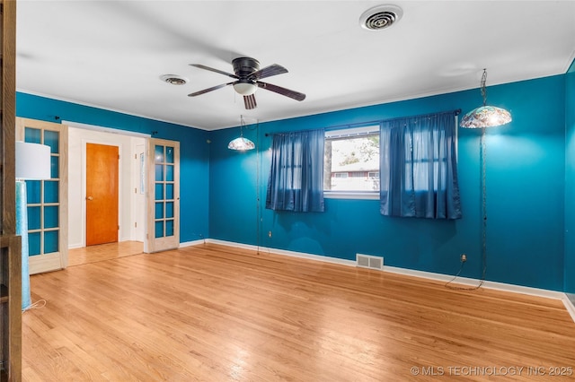 unfurnished room with a ceiling fan, baseboards, visible vents, and wood finished floors