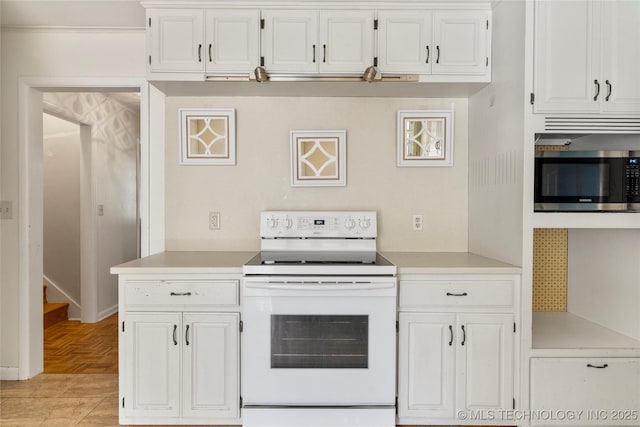 kitchen with light countertops, white range with electric cooktop, stainless steel microwave, and white cabinetry
