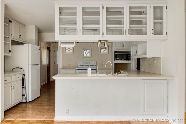kitchen with electric range, light countertops, freestanding refrigerator, a peninsula, and stainless steel microwave