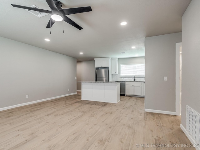 kitchen featuring visible vents, baseboards, a sink, light wood finished floors, and stainless steel appliances