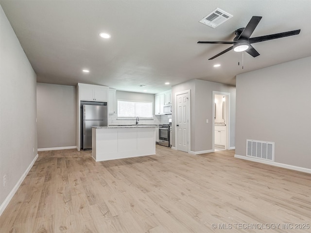 unfurnished living room featuring recessed lighting, baseboards, and visible vents