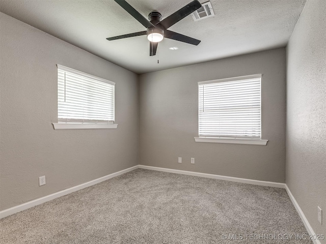 spare room featuring baseboards, a ceiling fan, carpet flooring, and visible vents