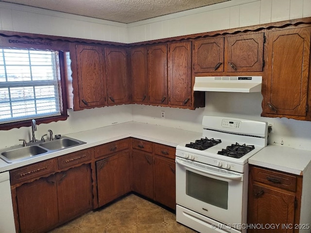 824 W Houston St, Okemah, OK 74859 - kitchen featuring white appliances, under cabinet range hood, a sink, a textured ceiling, and light countertops