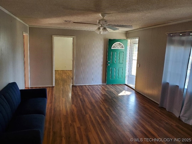 824 W Houston St, Okemah, OK 74859 - foyer entrance with ornamental molding, a textured ceiling, wood finished floors, a ceiling fan, and wood walls