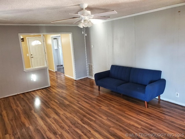 824 W Houston St, Okemah, OK 74859 - living area with wood finished floors, a ceiling fan, crown molding, a textured ceiling, and baseboards