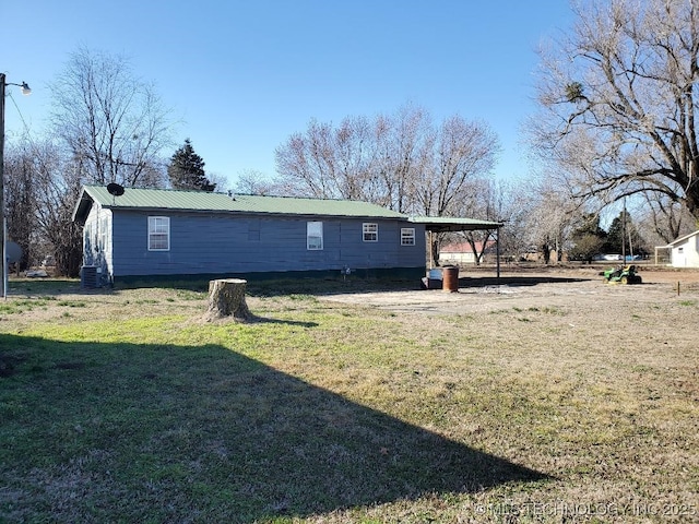 824 W Houston St, Okemah, OK 74859 - rear view of property featuring a carport, a yard, and metal roof