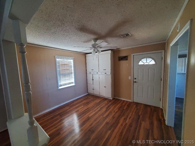 824 W Houston St, Okemah, OK 74859 - foyer with dark wood-style flooring, a ceiling fan, baseboards, crown molding, and a textured ceiling