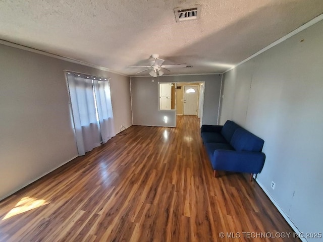 824 W Houston St, Okemah, OK 74859 - unfurnished living room with wood finished floors, a ceiling fan, crown molding, and a textured ceiling