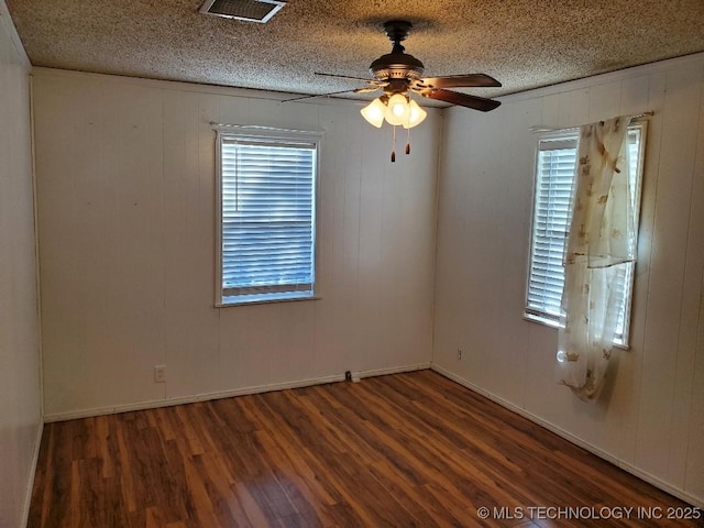 824 W Houston St, Okemah, OK 74859 - empty room featuring wood finished floors, ceiling fan, wooden walls, baseboards, and a textured ceiling