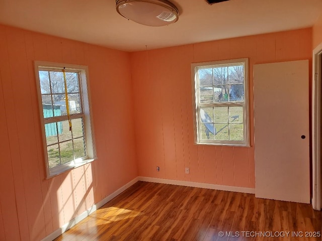 824 W Houston St, Okemah, OK 74859 - empty room with wood finished floors, plenty of natural light, and baseboards