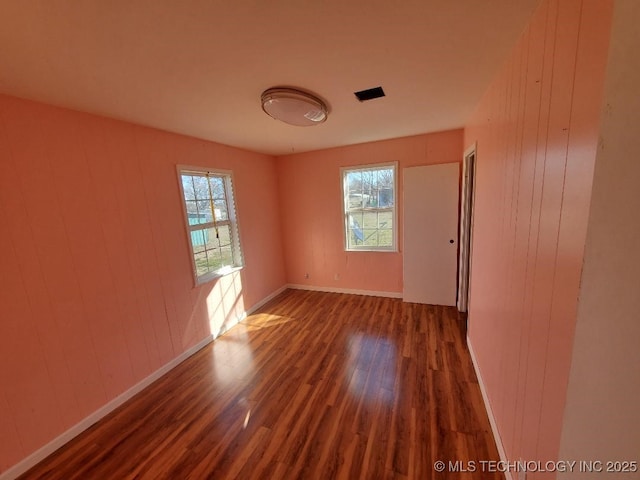 824 W Houston St, Okemah, OK 74859 - empty room featuring wood finished floors, baseboards, and wood walls