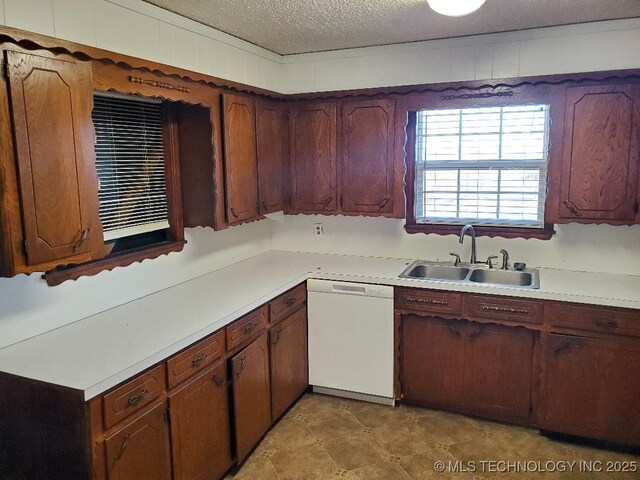 824 W Houston St, Okemah, OK 74859 - kitchen with white dishwasher, a sink, light countertops, and a textured ceiling