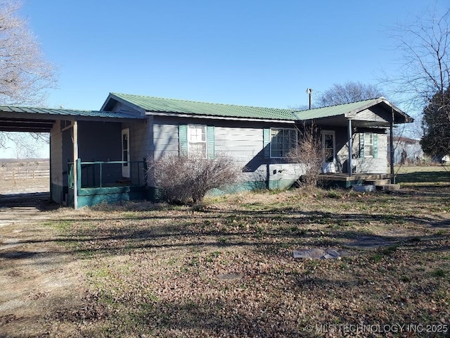 824 W Houston St, Okemah, OK 74859 - view of property exterior featuring covered porch, metal roof, and an attached carport