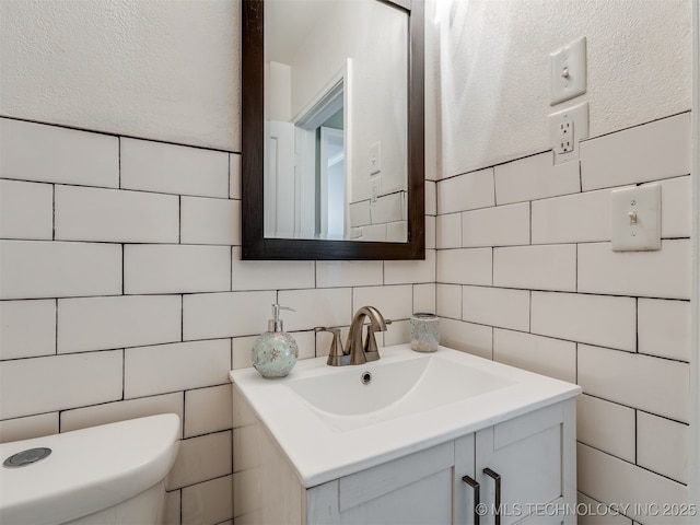 2236 S Marion Ave, Tulsa, OK 74114 - half bathroom with tile walls, toilet, and vanity